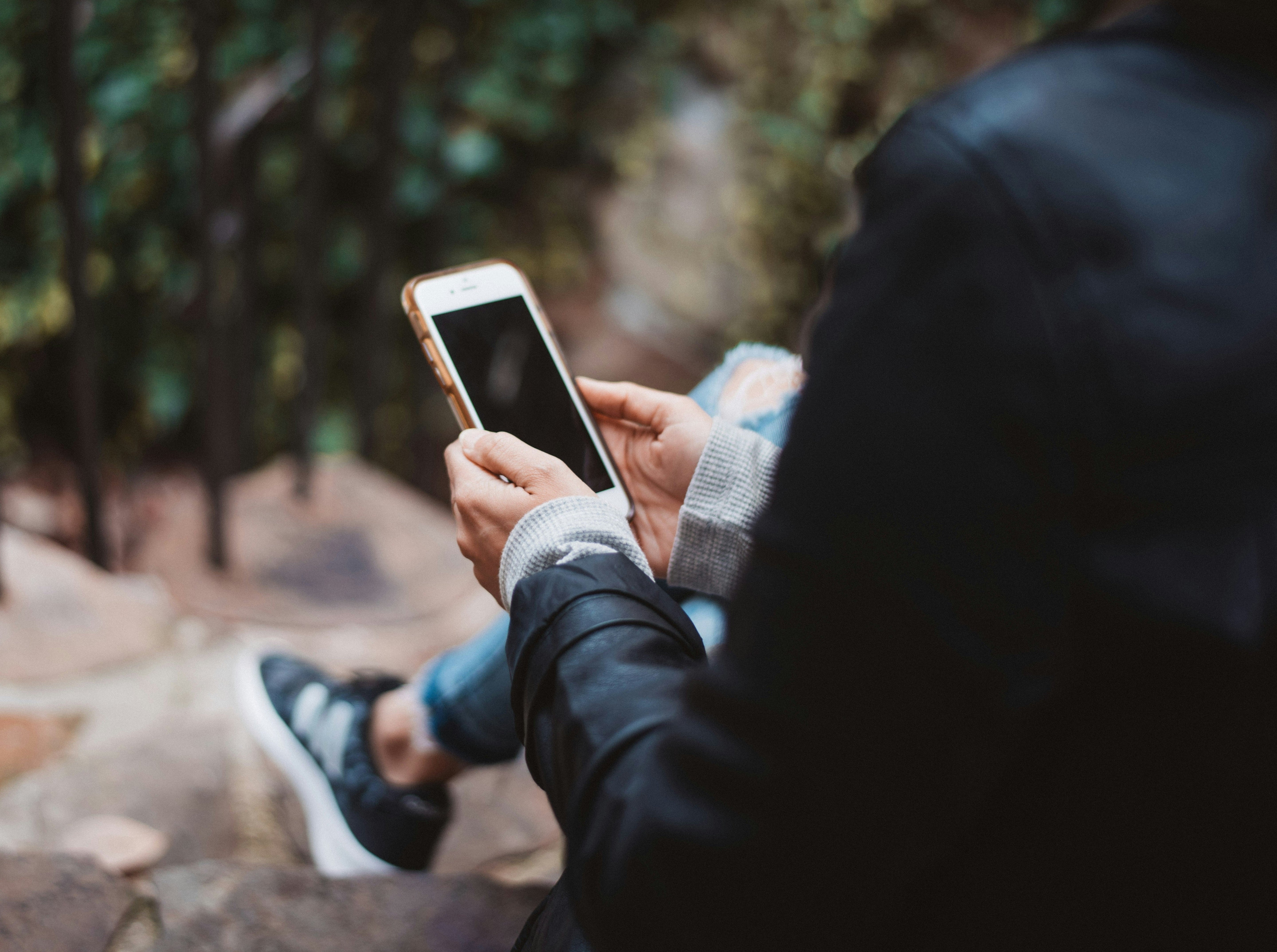 Woman scrolling her phone - blog by makers of organic cold-pressed fruit and vegetable Living Juice