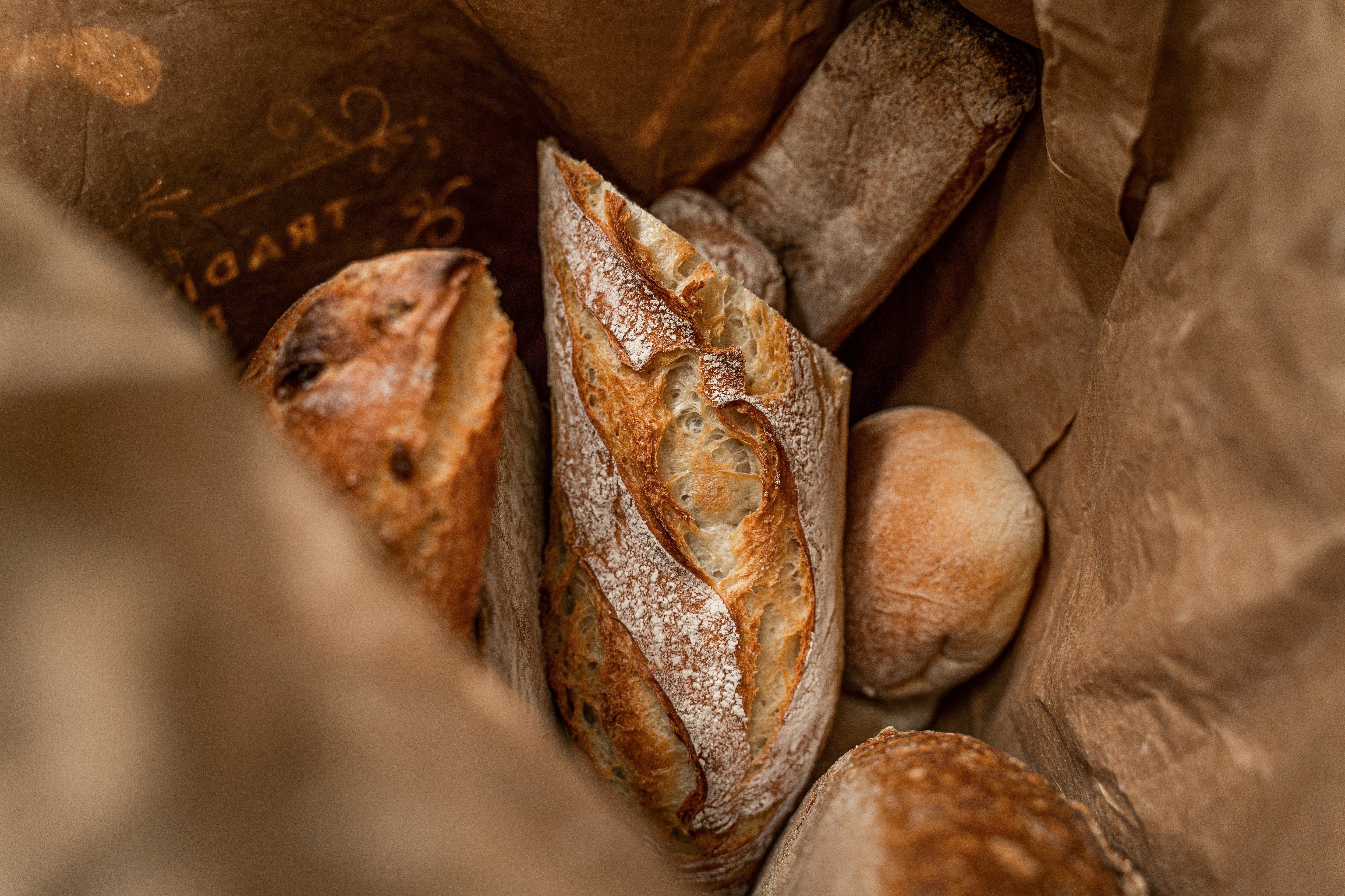 Variety of bread in brown paper bag - for blog by O2 Living makers of organic cold-pressed Living Juice