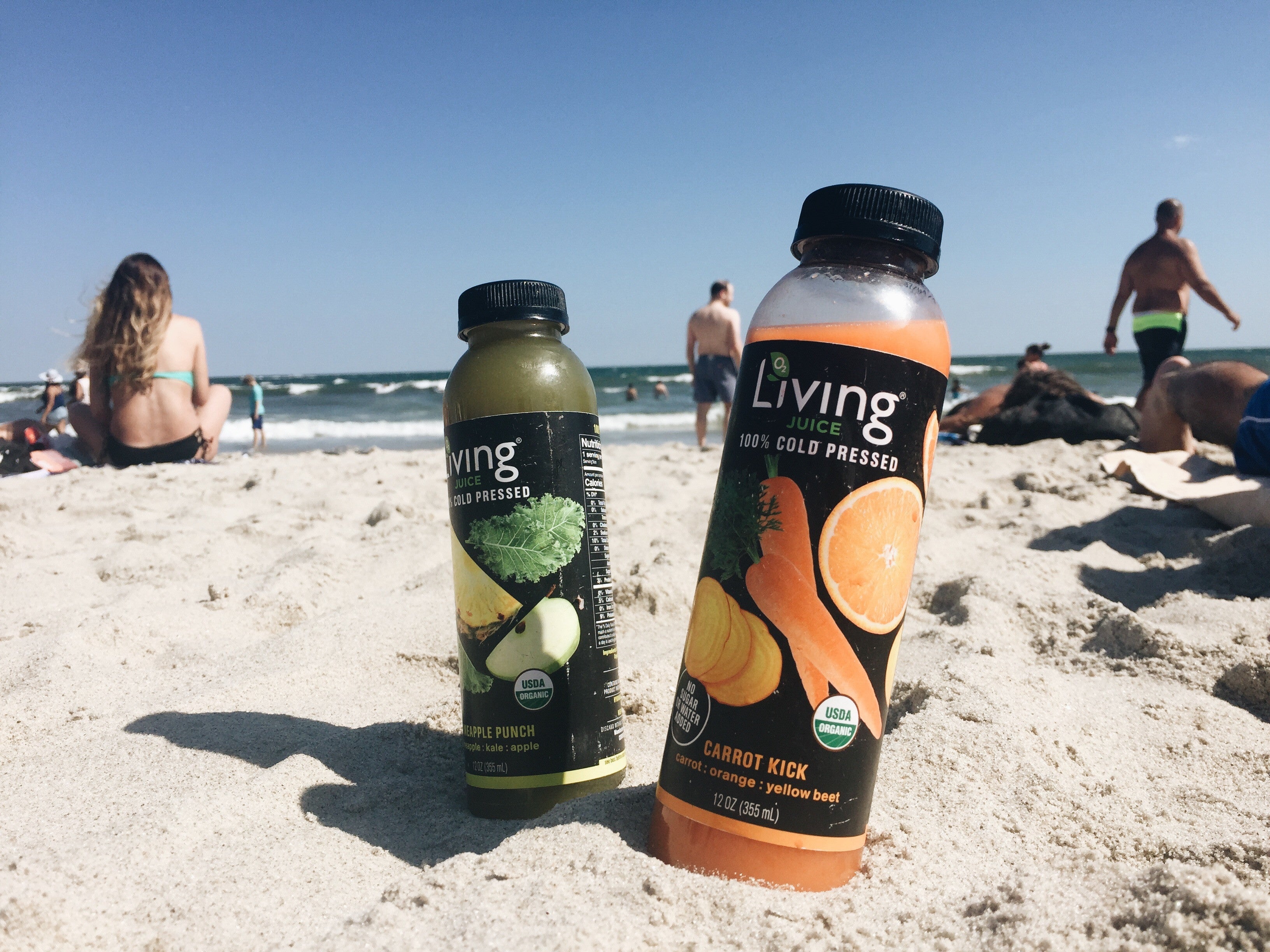 Living Juice organic cold-pressed fruit and vegetable juices Carrot Kick and Green Vitality on the beach