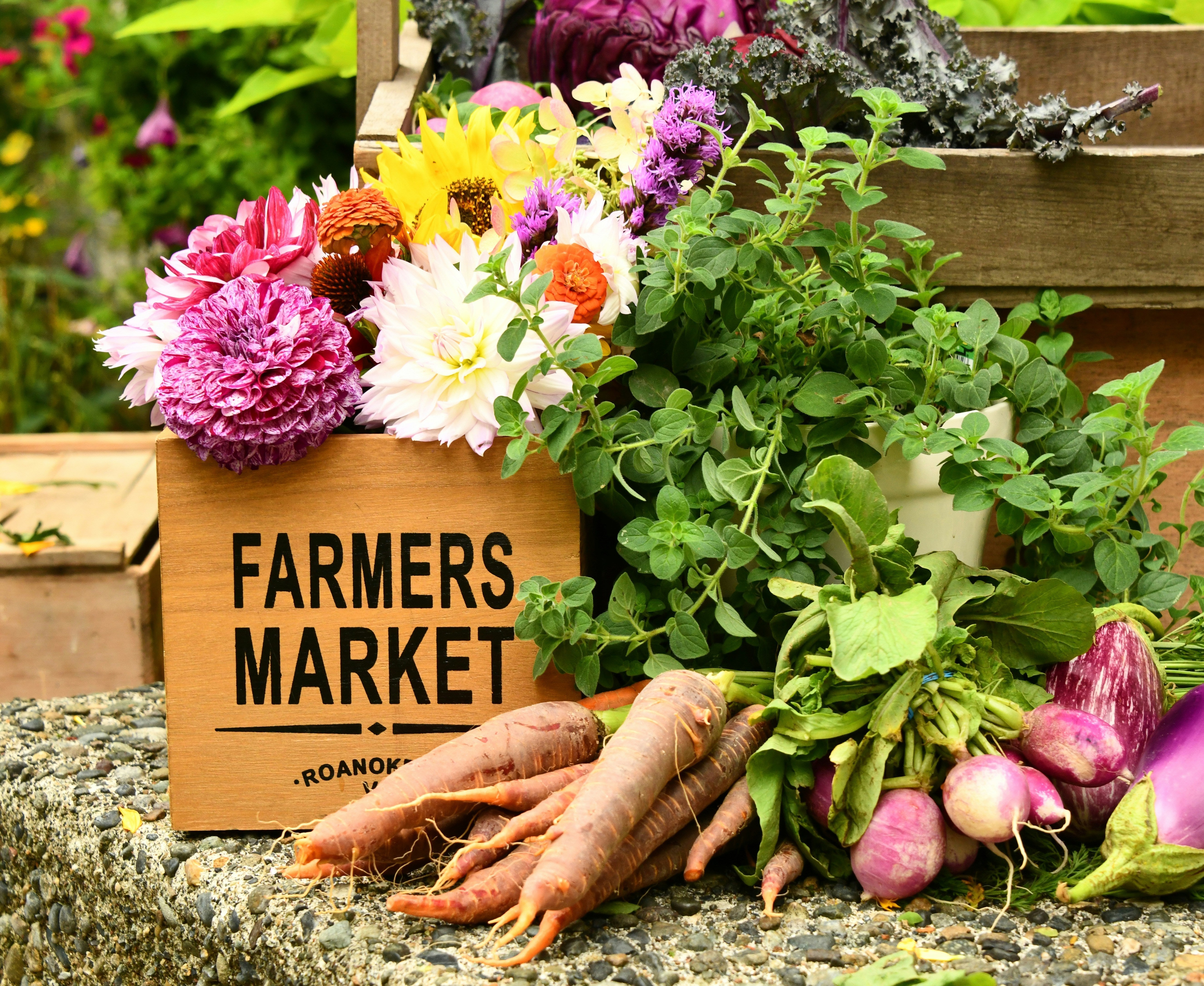 Farmers Market Box - filled with flowers and carrots - blog by Living Juice organic cold-pressed fruit and vegetable juice