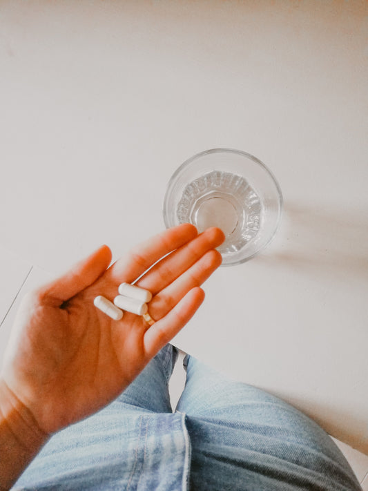 person taking ashwagandha white capsule pill